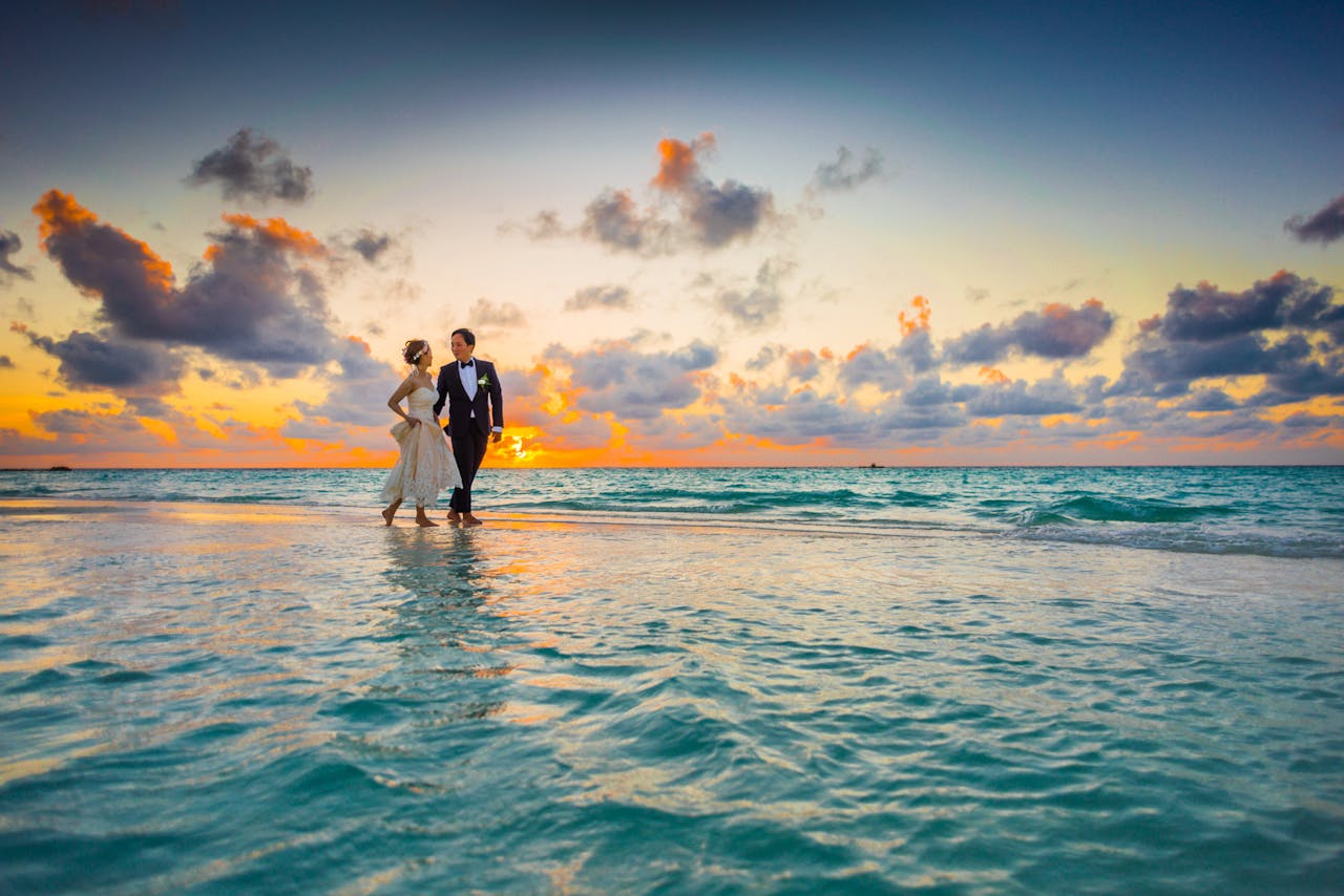 A happy couple walking down the beach after getting married
