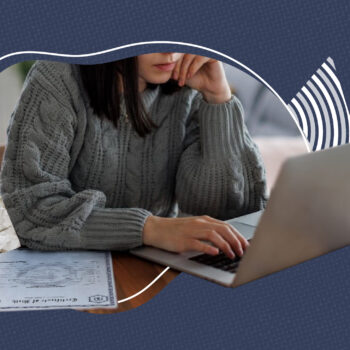 Person wearing a gray sweater sitting at a desk using a laptop, with a death certificate partially visible on the table. A crumpled paper with a question mark is placed beside the document, symbolizing confusion or inquiry about official records or personal documentation.