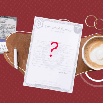 A marriage certificate with a large red question mark in the center lies on a wooden surface next to a cup of coffee and two gold wedding rings. Nearby are a calendar, a pen, and another document, all set against a maroon background with a subtle dotted pattern. The image conveys uncertainty or confusion about the status or receipt of a marriage certificate.